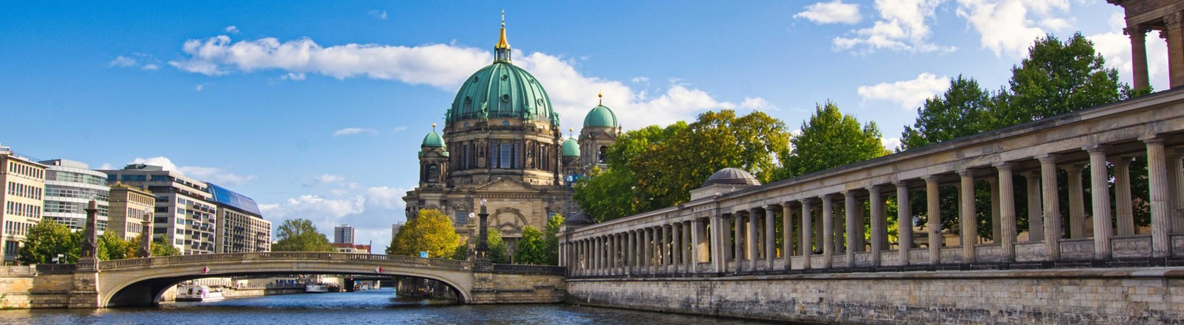 Brandenburger Tor in Berlin bei Sonnenuntergang mit einer springenden Fontäne im Vordergrund