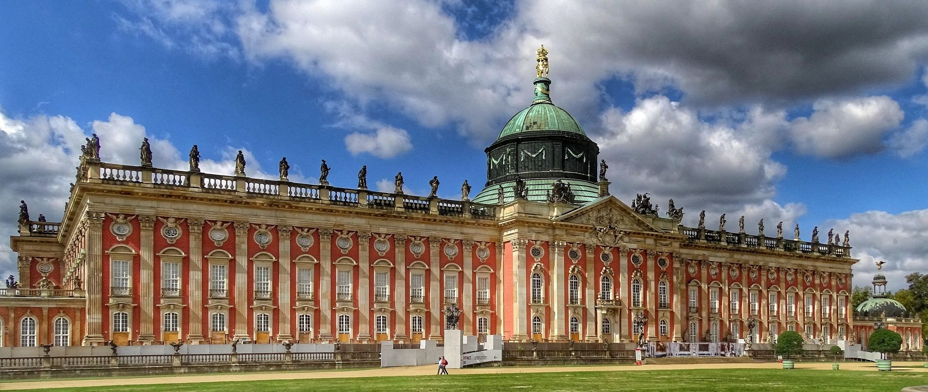 Historisches Schloss mit prächtiger Fassade und Kuppel unter bewölktem Himmel